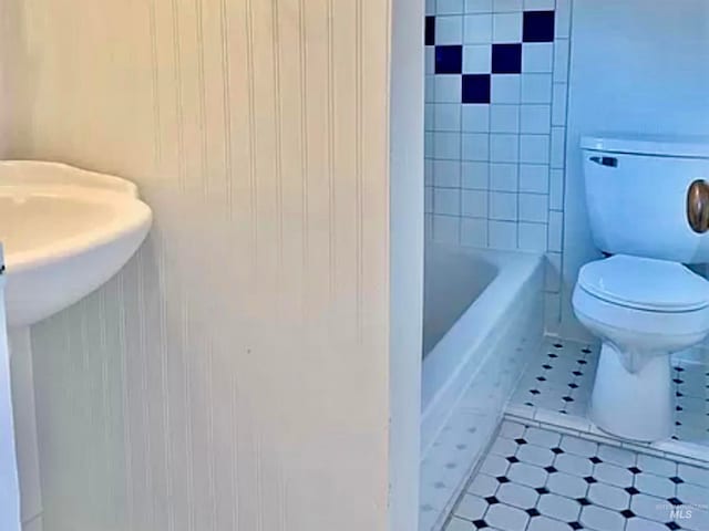 bathroom featuring toilet, shower with separate bathtub, and tile patterned flooring