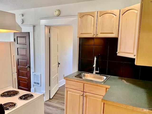 kitchen with white appliances, light brown cabinetry, sink, and light wood-type flooring