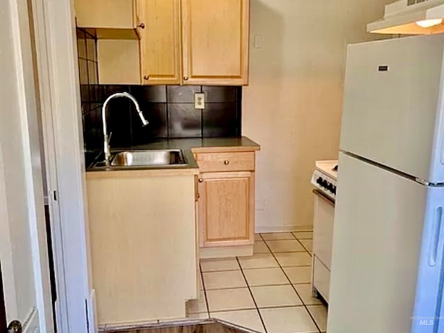 kitchen featuring light tile patterned flooring, light brown cabinets, sink, and white appliances