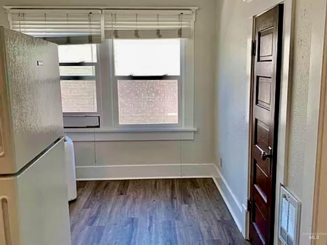 unfurnished dining area with a healthy amount of sunlight and dark wood-type flooring