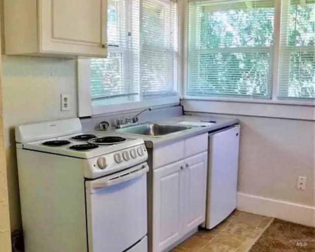 kitchen with white appliances, sink, and white cabinets