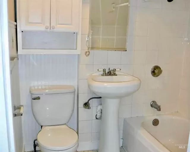 full bathroom featuring backsplash, tile walls, shower / bathing tub combination, and toilet