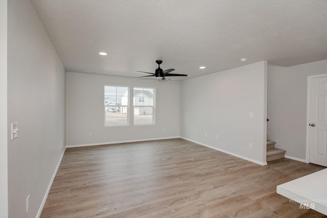 empty room with ceiling fan and light hardwood / wood-style floors