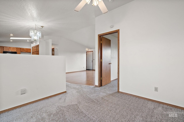 607 S State, Nampa, ID 83686 - unfurnished room featuring light carpet, a chandelier, a ceiling fan, baseboards, and lofted ceiling