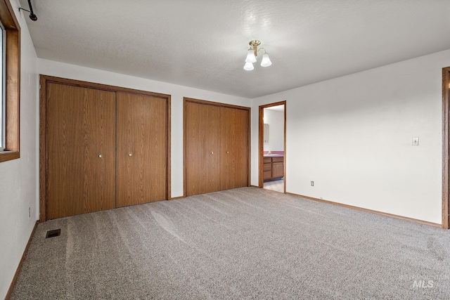 607 S State, Nampa, ID 83686 - unfurnished bedroom with two closets, carpet flooring, and baseboards