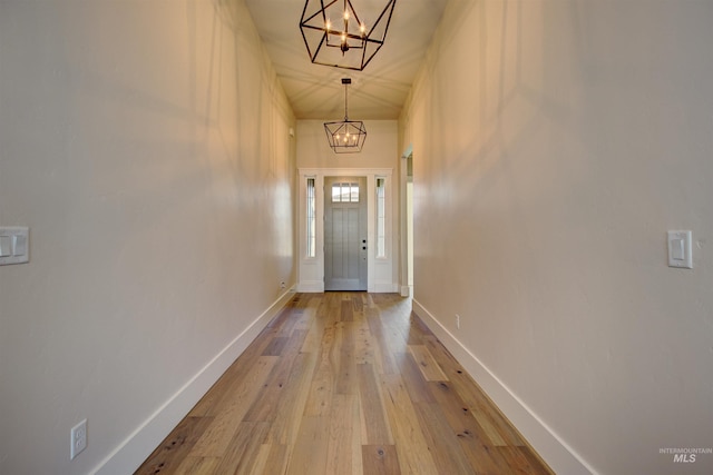 doorway featuring light hardwood / wood-style floors and an inviting chandelier