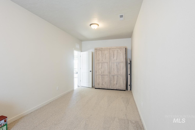 unfurnished room featuring light carpet