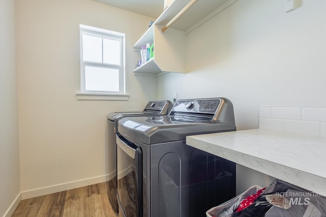 laundry room with hardwood / wood-style floors and washing machine and dryer