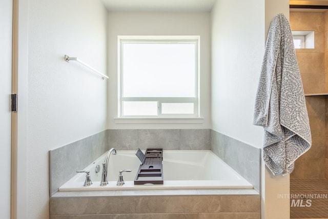 bathroom featuring tiled tub