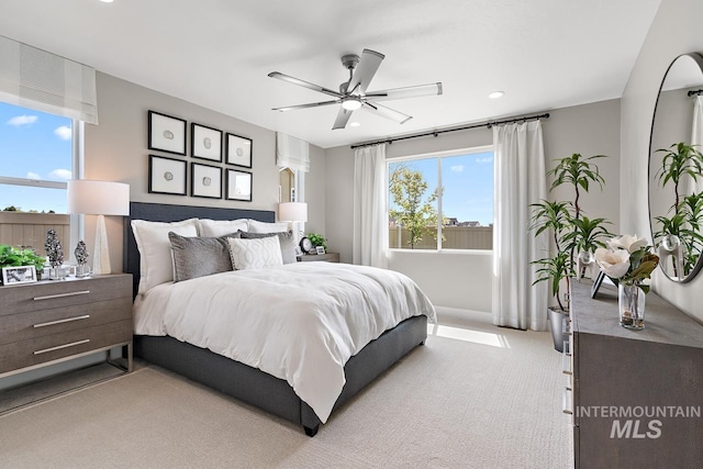 carpeted bedroom featuring ceiling fan and multiple windows