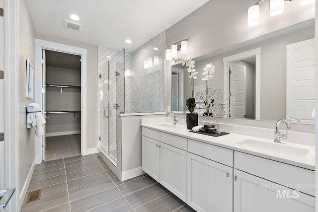 bathroom featuring double sink vanity, walk in shower, and tile patterned floors