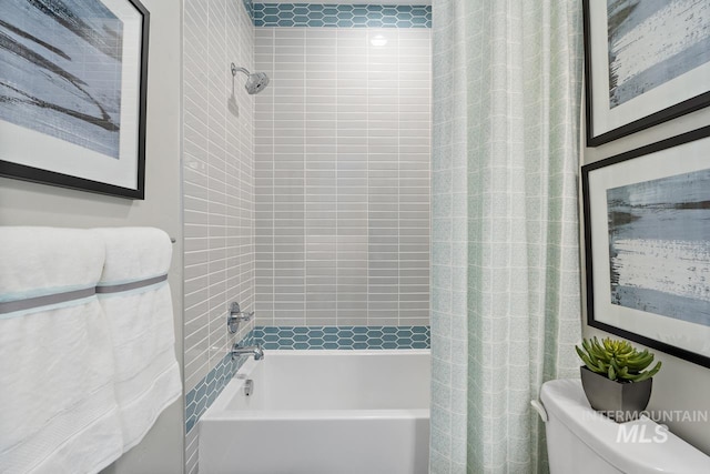 bathroom featuring shower / tub combo and toilet