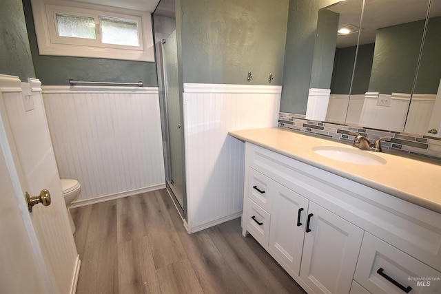 123 15th Ave, Lewiston, ID 83501 - bathroom with wainscoting, toilet, wood finished floors, a stall shower, and vanity