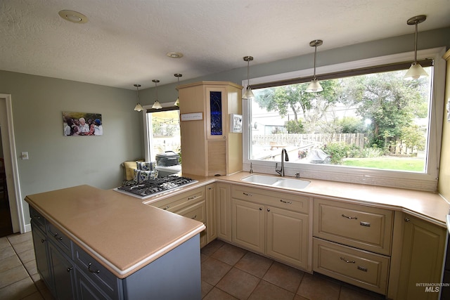 123 15th Ave, Lewiston, ID 83501 - kitchen with a sink, stainless steel gas stovetop, tile patterned flooring, light countertops, and decorative light fixtures