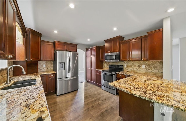 10539 W Merab Ct, Star, ID 83669 - kitchen with appliances with stainless steel finishes, tasteful backsplash, light stone counters, dark wood finished floors, and recessed lighting