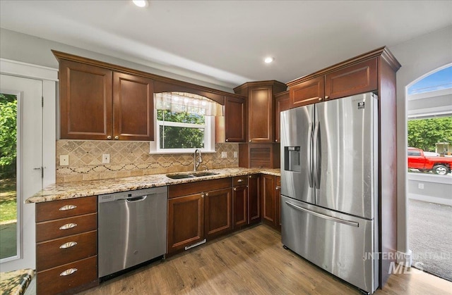 10539 W Merab Ct, Star, ID 83669 - kitchen featuring appliances with stainless steel finishes, dark wood-style flooring, decorative backsplash, light stone counters, and recessed lighting