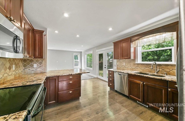 10539 W Merab Ct, Star, ID 83669 - kitchen with stainless steel appliances, recessed lighting, light wood-type flooring, plenty of natural light, and decorative backsplash