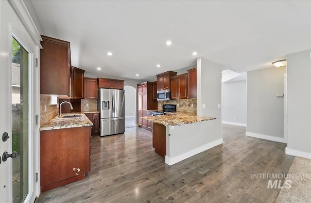 10539 W Merab Ct, Star, ID 83669 - kitchen featuring stainless steel appliances, tasteful backsplash, light stone countertops, dark wood finished floors, and recessed lighting