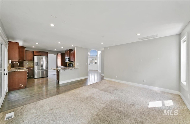 10539 W Merab Ct, Star, ID 83669 - unfurnished living room featuring carpet, arched walkways, recessed lighting, and wood finished floors