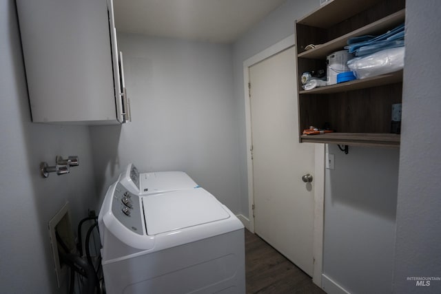 laundry area featuring dark wood-style flooring, cabinet space, and washer and clothes dryer