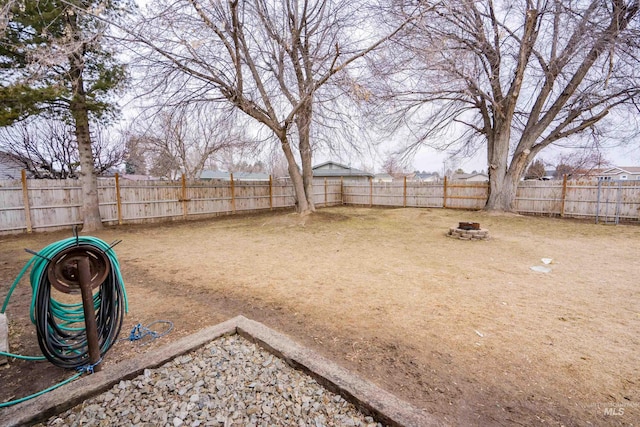 view of yard with a fire pit and a fenced backyard