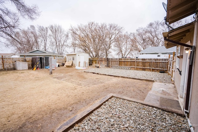 view of yard featuring an outbuilding, a patio area, a fenced backyard, and a shed