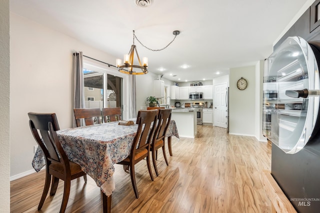 dining area with recessed lighting, baseboards, light wood-style floors, and a chandelier