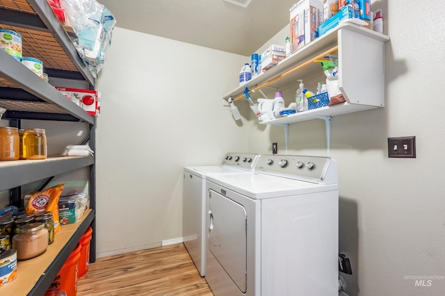 laundry room featuring laundry area, light wood-style floors, baseboards, and washing machine and clothes dryer