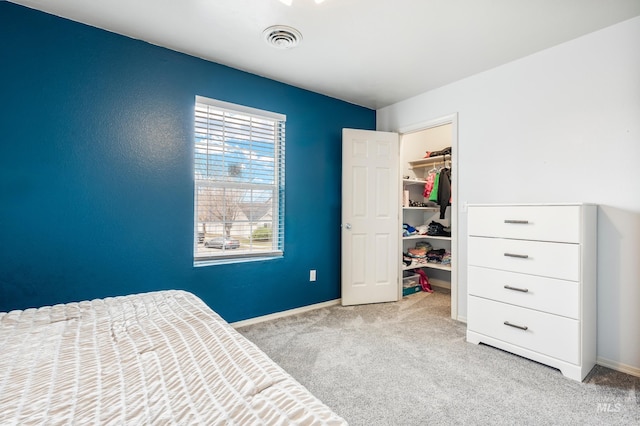 bedroom with baseboards, visible vents, a closet, a walk in closet, and carpet flooring