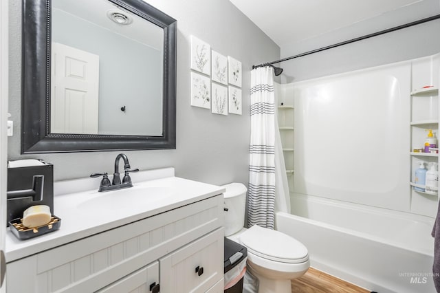 full bathroom with visible vents, toilet, wood finished floors, shower / tub combo, and vanity