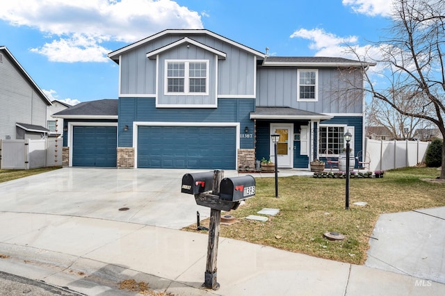 view of front of house with a front lawn, concrete driveway, a garage, and fence