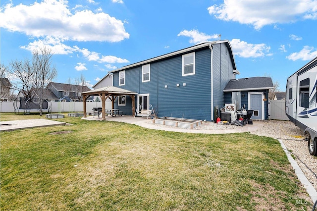 back of property featuring a patio, a gate, a fenced backyard, a trampoline, and a lawn