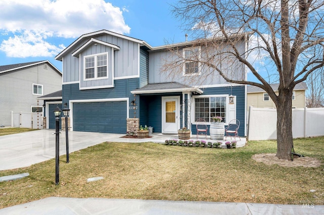 view of front of house with driveway, fence, board and batten siding, a front yard, and a garage