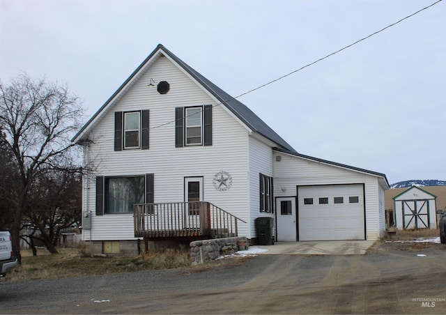 view of front of house featuring a garage and a shed