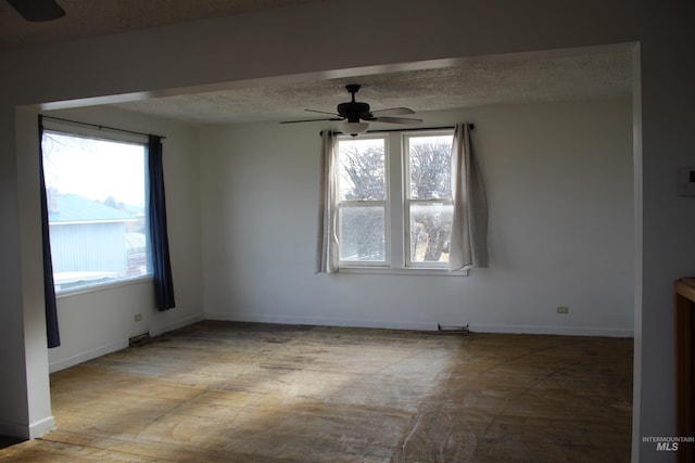 spare room with ceiling fan, plenty of natural light, and a textured ceiling