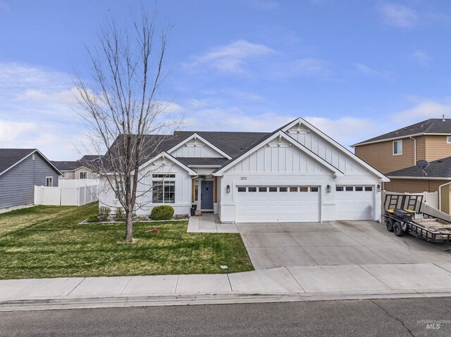 view of front of home featuring a front yard, a garage, board and batten siding, fence, and concrete driveway