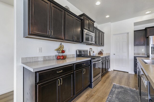 kitchen featuring appliances with stainless steel finishes, light wood finished floors, light countertops, and recessed lighting