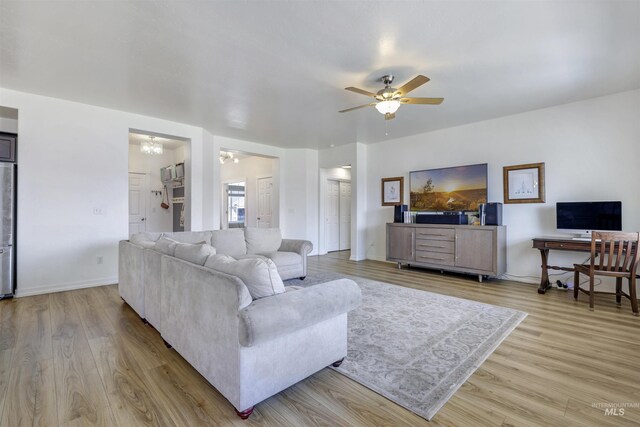 living room with light wood-type flooring, baseboards, and a ceiling fan