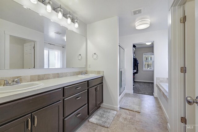 bathroom with visible vents, a sink, and a healthy amount of sunlight