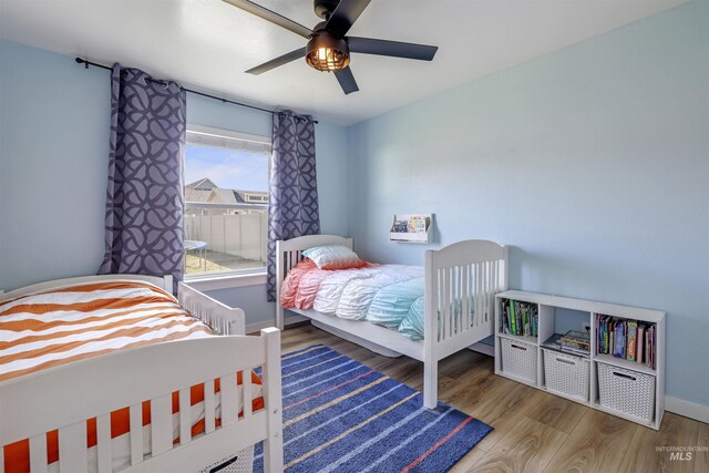 bedroom featuring baseboards, a ceiling fan, and wood finished floors