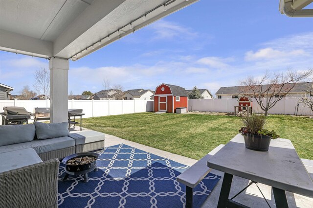 view of patio / terrace with a storage shed, a fenced backyard, an outdoor structure, outdoor dining area, and a residential view