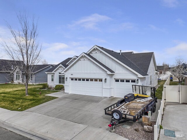 view of front of home with board and batten siding, a garage, a front lawn, a gate, and concrete driveway