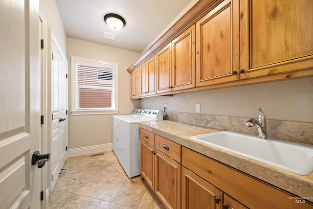 laundry room featuring visible vents, a sink, baseboards, cabinet space, and separate washer and dryer