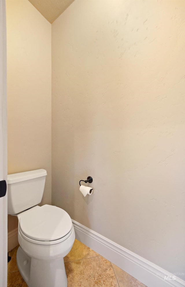 bathroom with tile patterned flooring, toilet, and baseboards