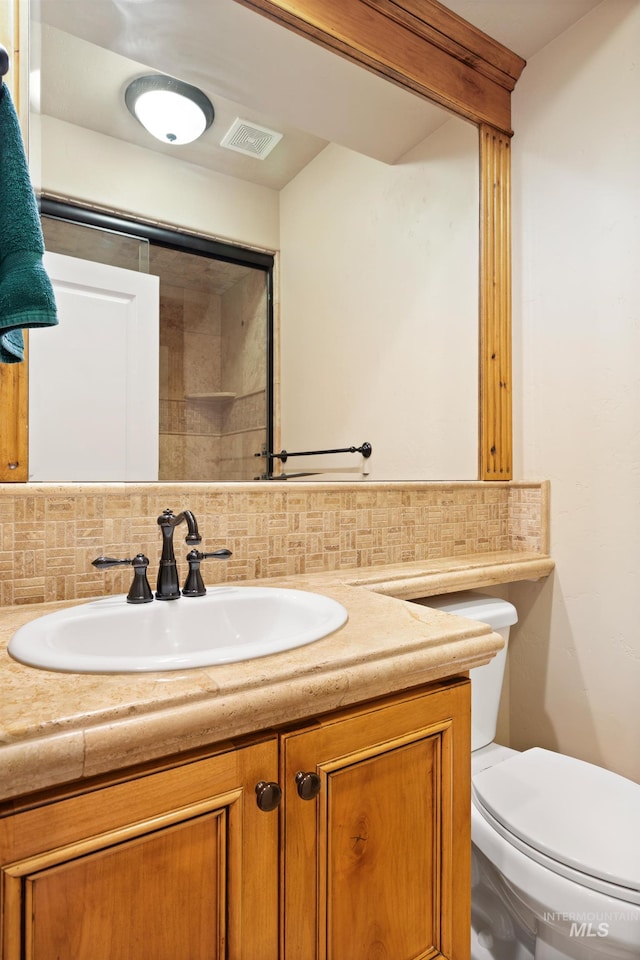 half bath with tasteful backsplash, visible vents, toilet, and vanity