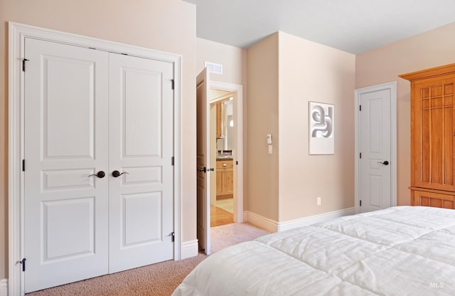 carpeted bedroom featuring visible vents, baseboards, and a closet