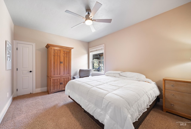 bedroom with a ceiling fan, baseboards, and light carpet