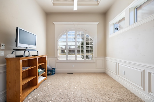 office space featuring a wainscoted wall, carpet, visible vents, and a decorative wall