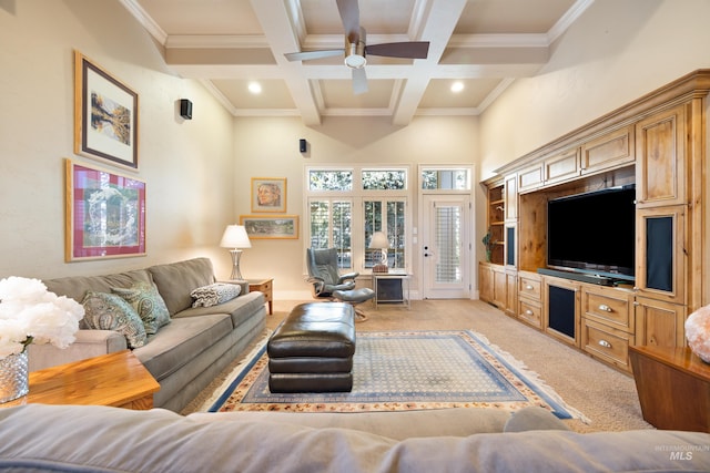 living area with beamed ceiling, light colored carpet, ornamental molding, coffered ceiling, and a ceiling fan