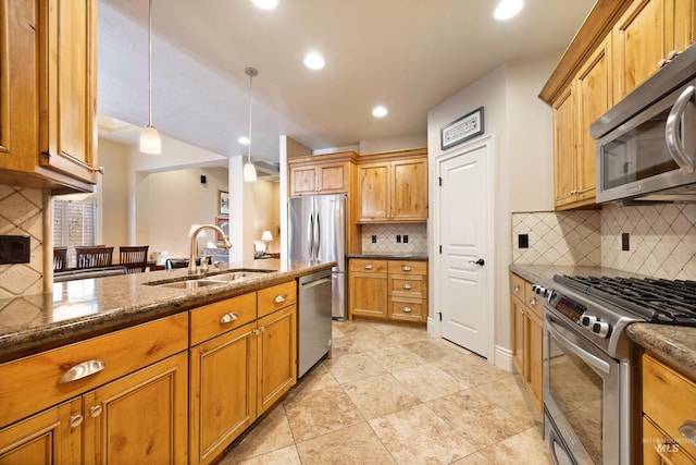 kitchen featuring pendant lighting, a sink, dark stone countertops, stainless steel appliances, and decorative backsplash